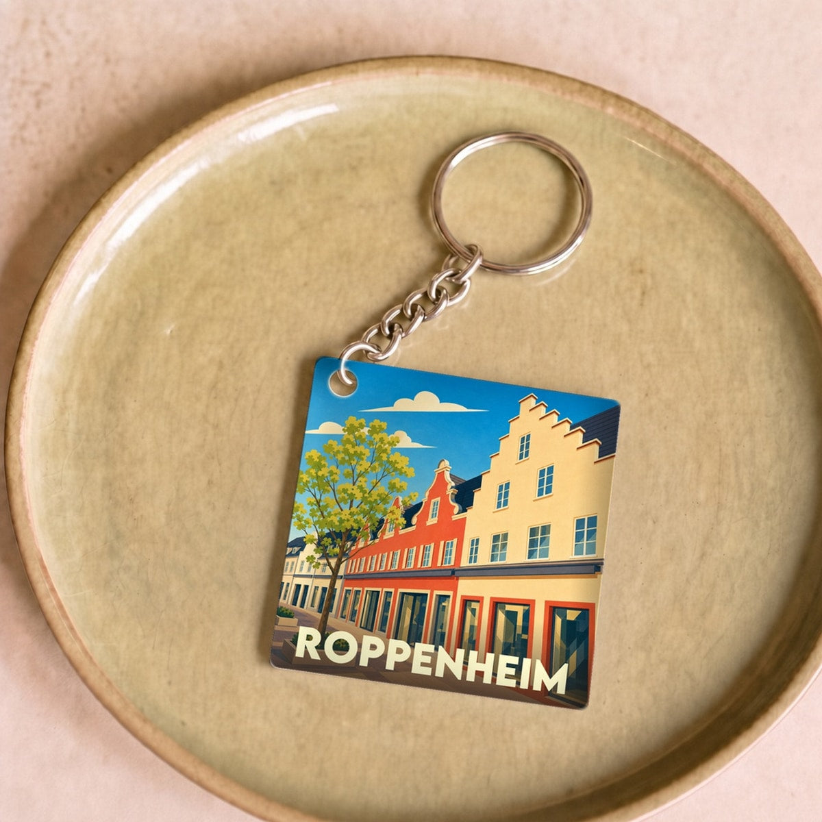 Porte-clés souvenir de la ville de Roppenheim avec une illustration stylisée de ses façades colorées.