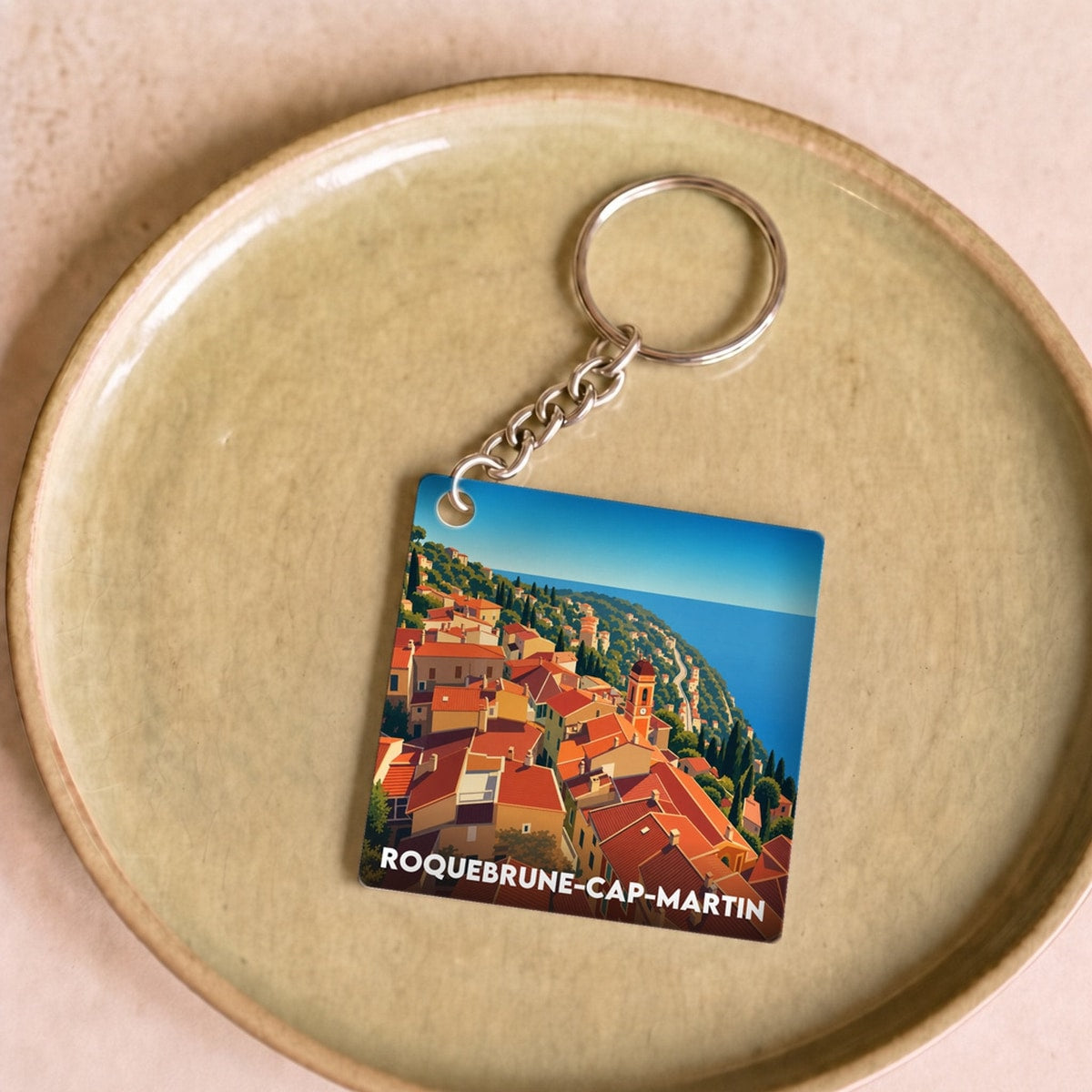 Porte-clés souvenir de la ville de Roquebrune-Cap-Martin avec une illustration stylisée.