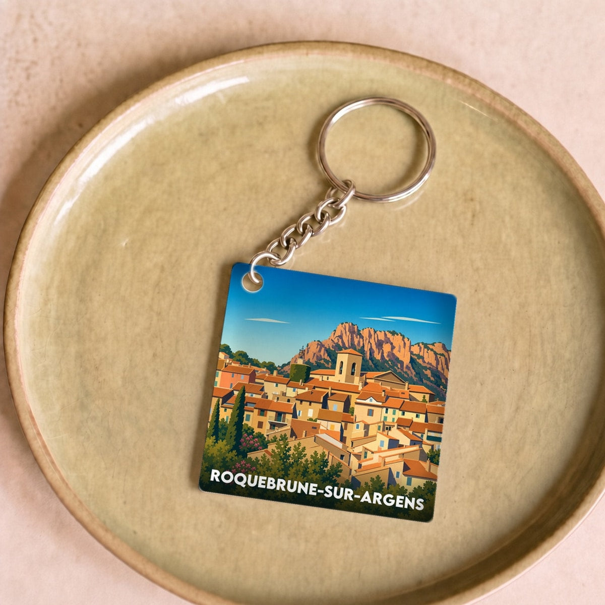 Porte-clés souvenir de la ville de Roquebrune-sur-Argens avec une illustration stylisée.