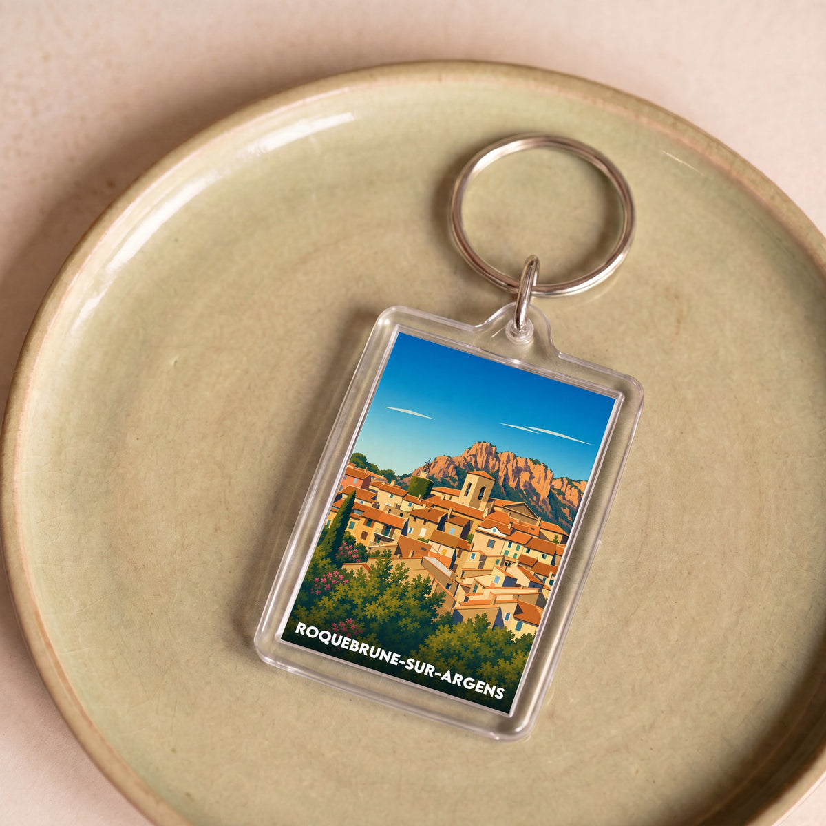 Porte-clés souvenir de la ville de Roquebrune-sur-Argens avec une illustration stylisée.