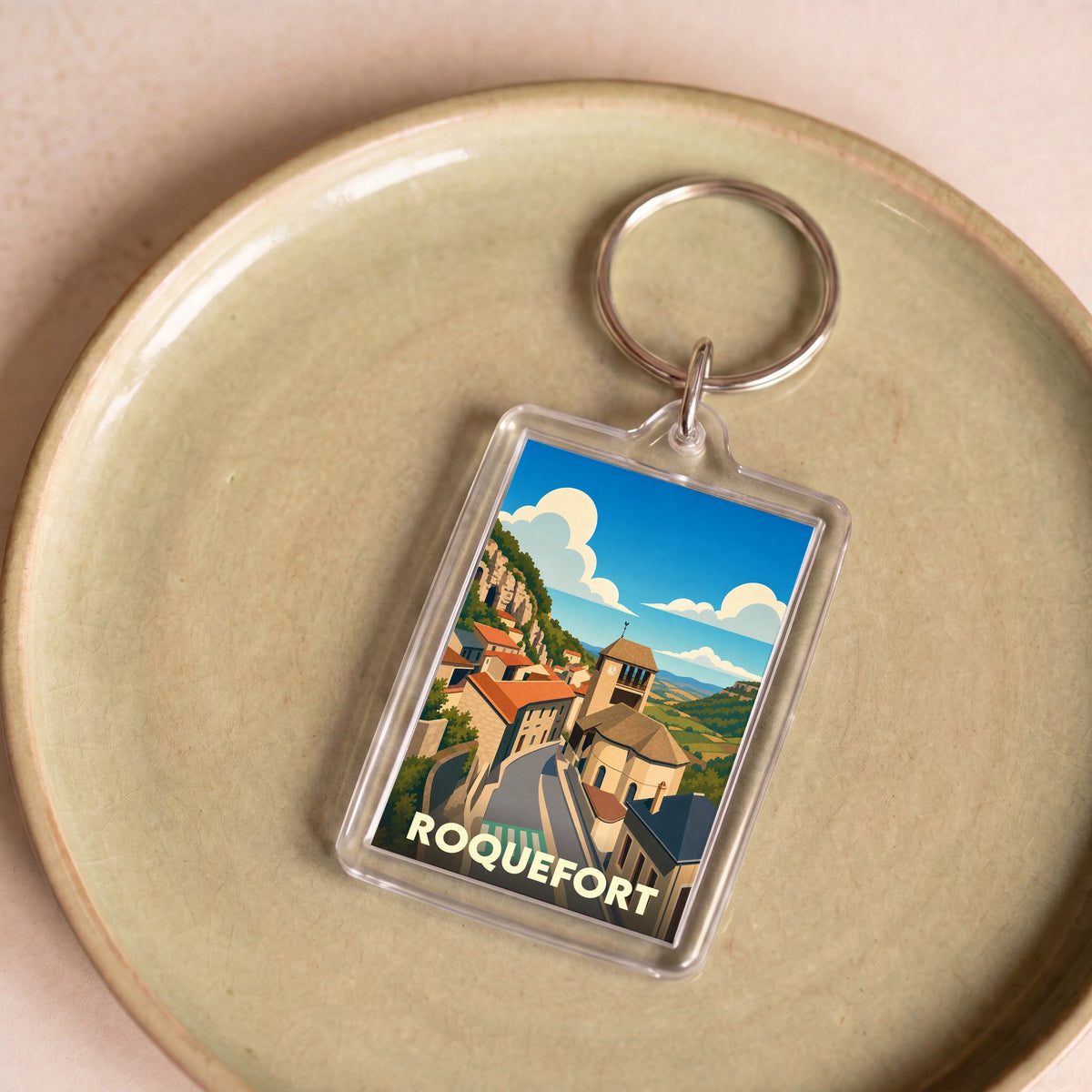Porte-clés souvenir de la ville de Roquefort avec une illustration stylisée.