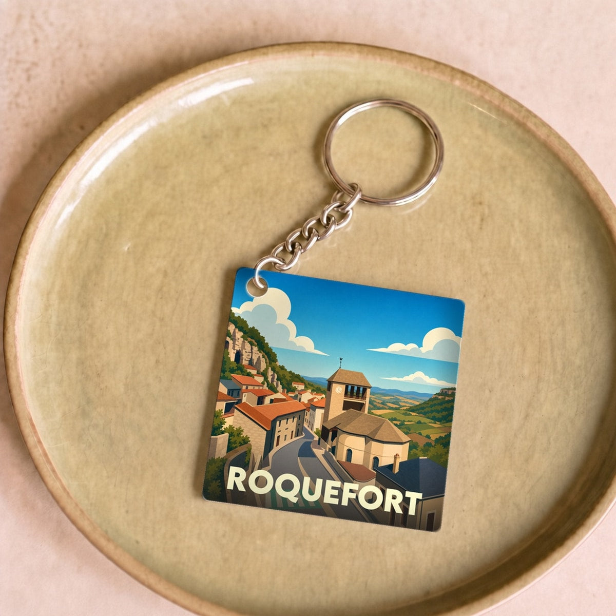 Porte-clés souvenir de la ville de Roquefort avec une illustration stylisée.