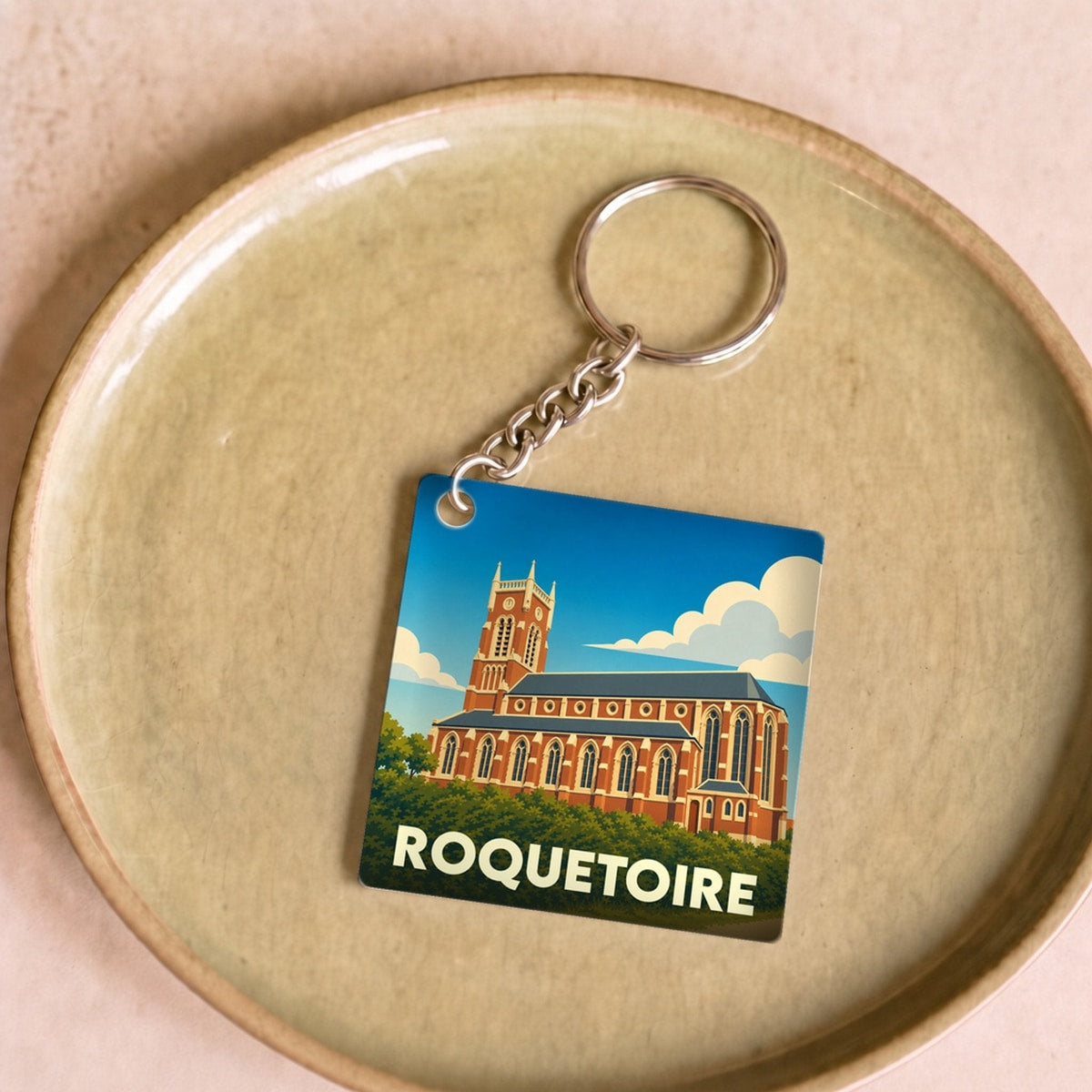 Porte-clés souvenir de la ville de Roquetoire avec une illustration stylisée de son église.