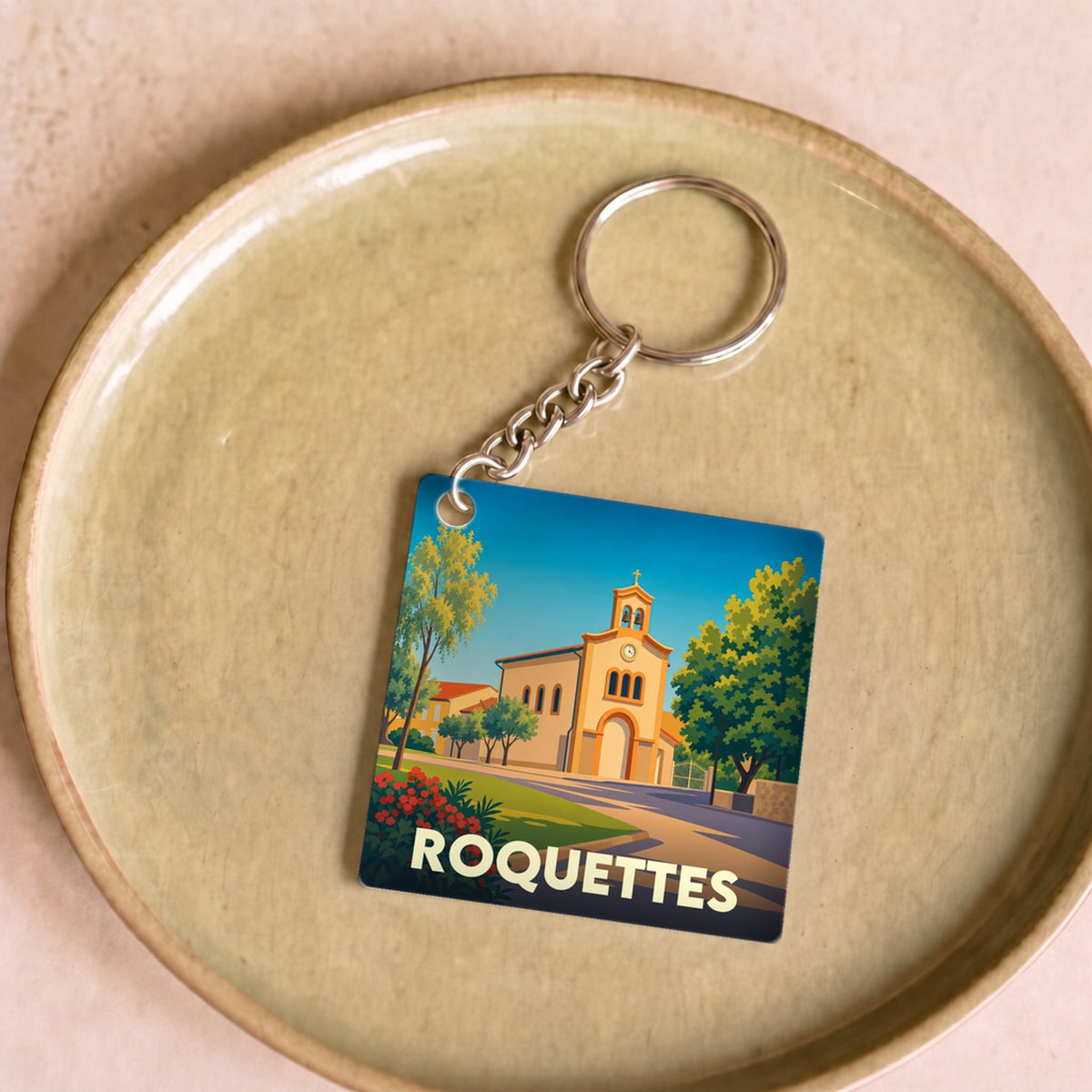 Porte-clés souvenir de la ville de Roquettes avec une illustration stylisée.