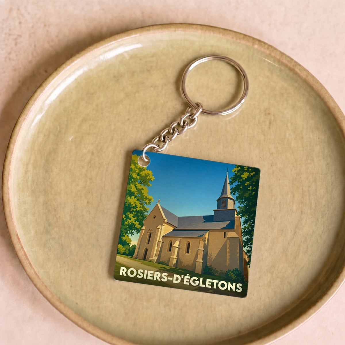 Porte-clés souvenir de la ville de Rosiers-d'Égletons avec une illustration stylisée de son église.