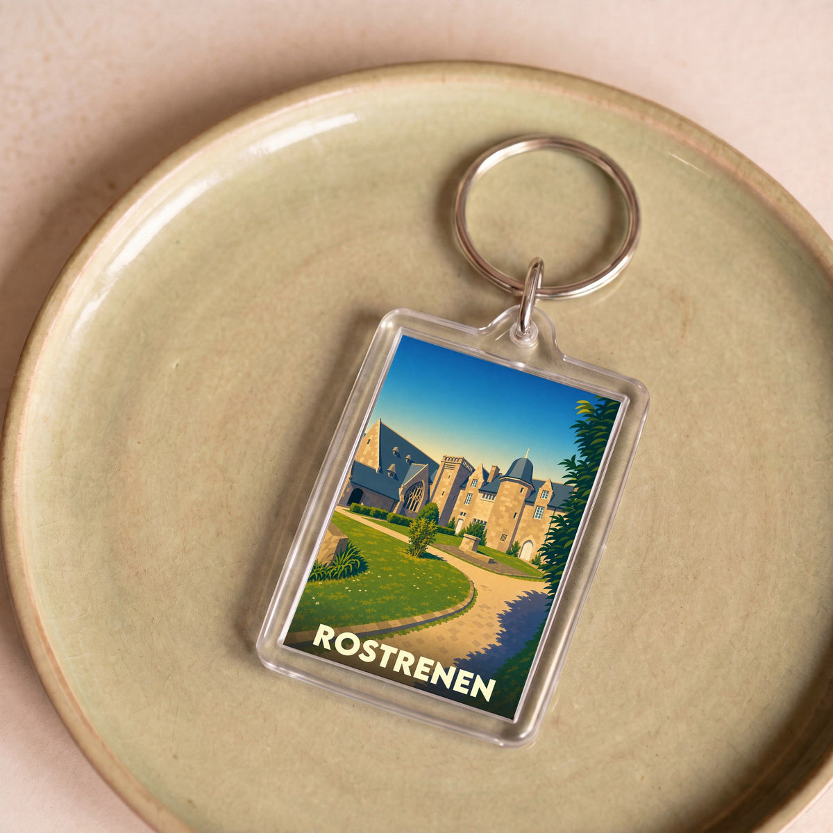 Porte-clés souvenir de la ville de Rostrenen avec une illustration stylisée de son patrimoine.