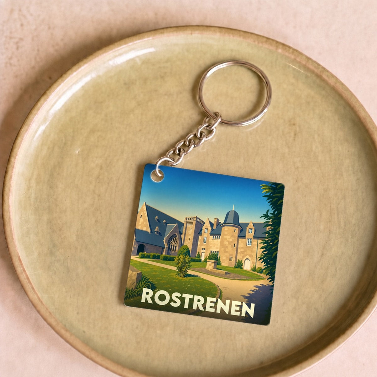 Porte-clés souvenir de la ville de Rostrenen avec une illustration stylisée de son patrimoine.