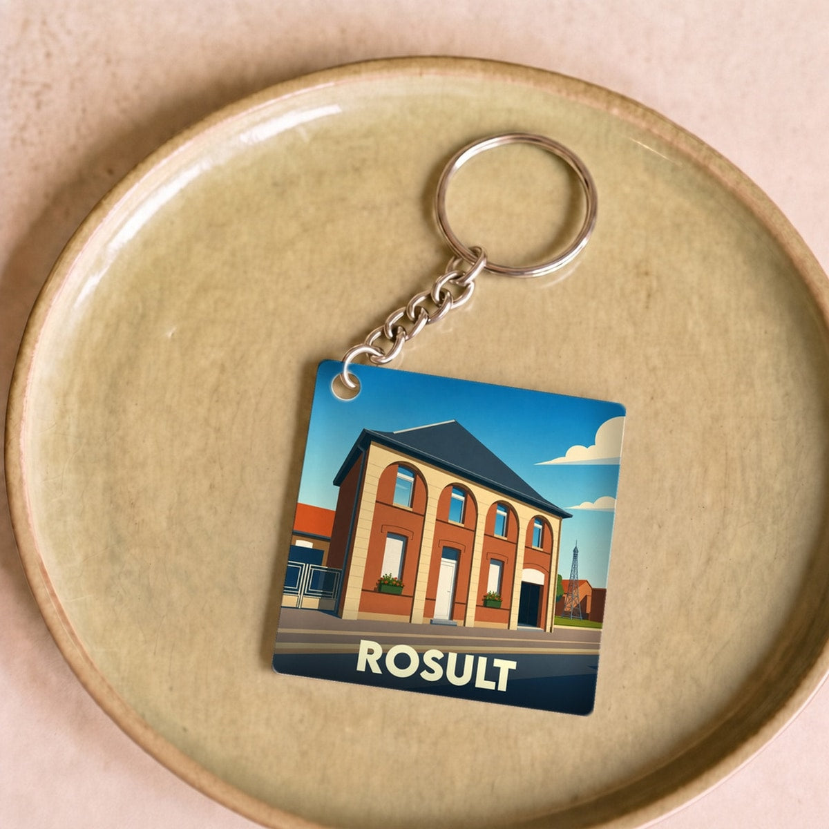 Porte-clés souvenir de la ville de Rosult avec une illustration stylisée de sa mairie.