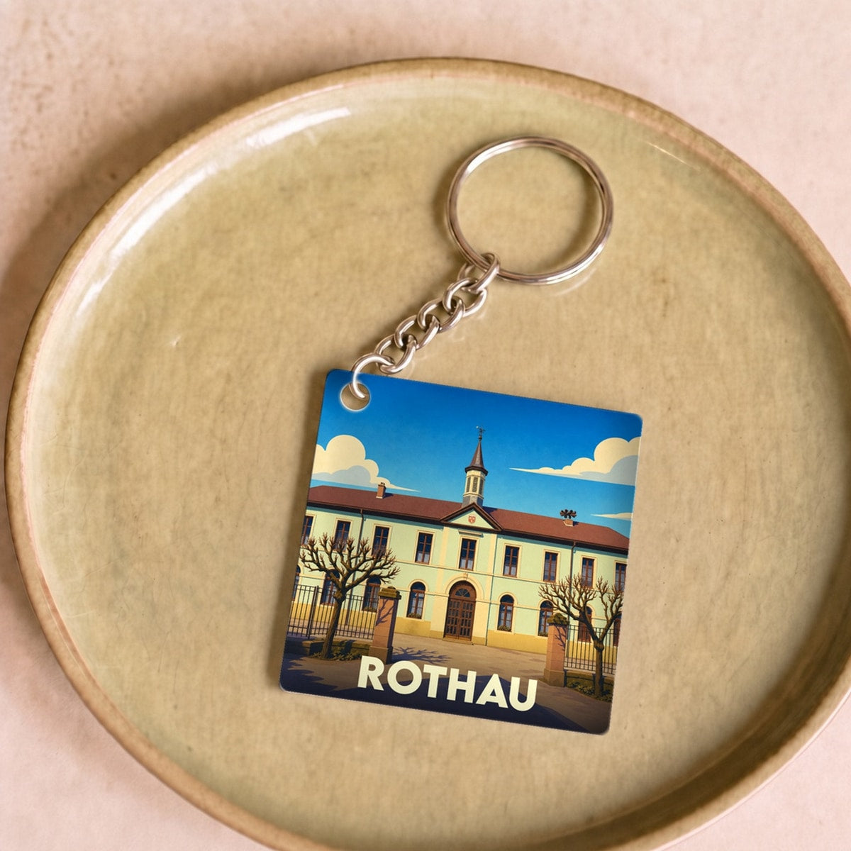 Porte-clés souvenir de la ville de Rothau avec une illustration stylisée de son architecture.