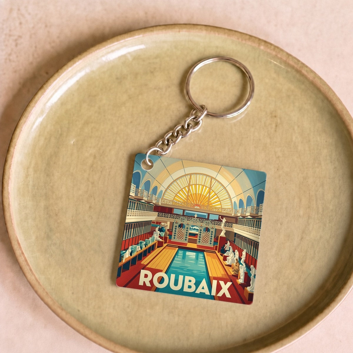 Porte-clés souvenir de la ville de Roubaix avec une illustration stylisée.