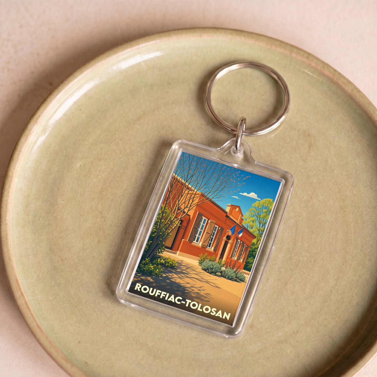Porte-clés souvenir de la ville de Rouffiac-Tolosan avec une illustration stylisée de sa mairie.