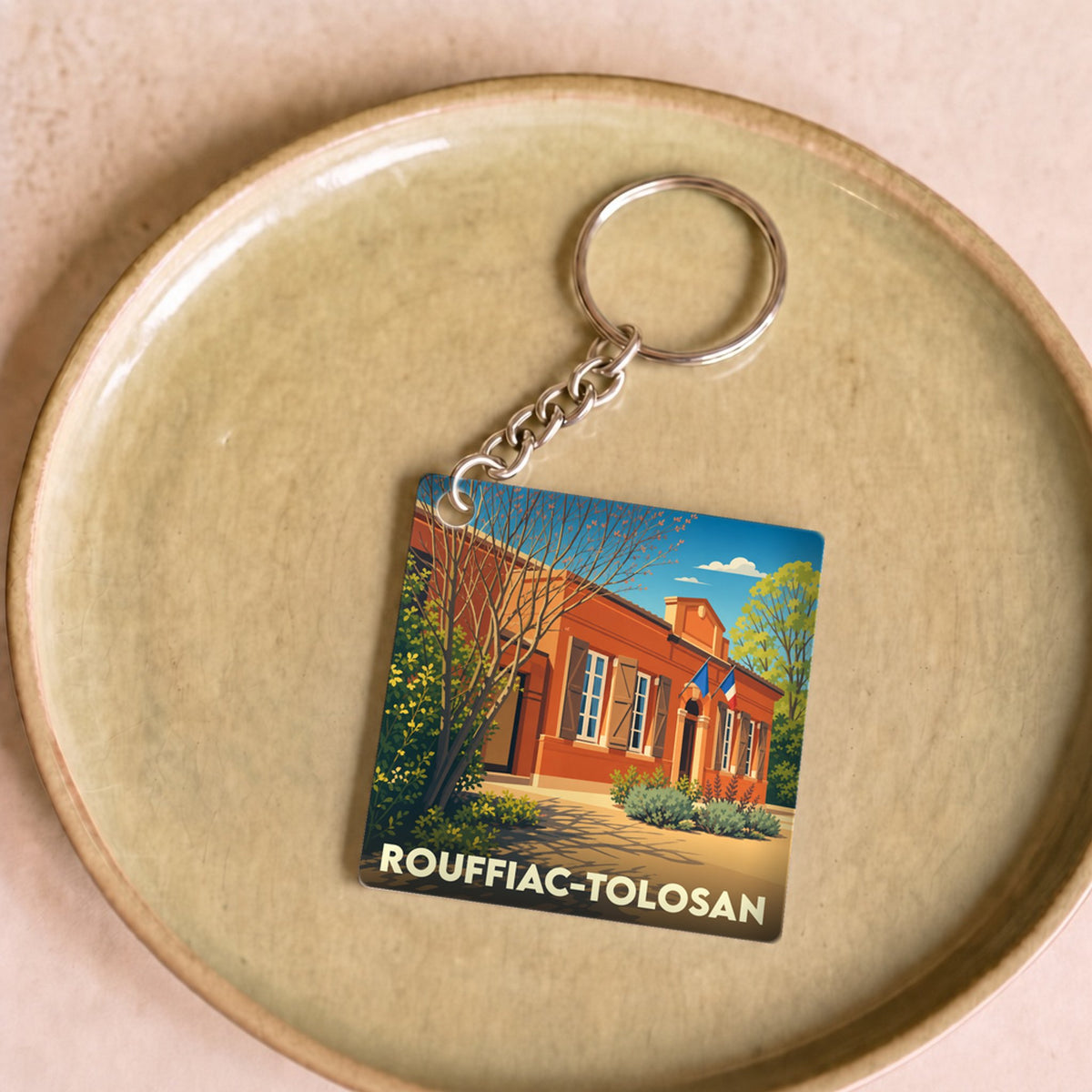 Porte-clés souvenir de la ville de Rouffiac-Tolosan avec une illustration stylisée de sa mairie.
