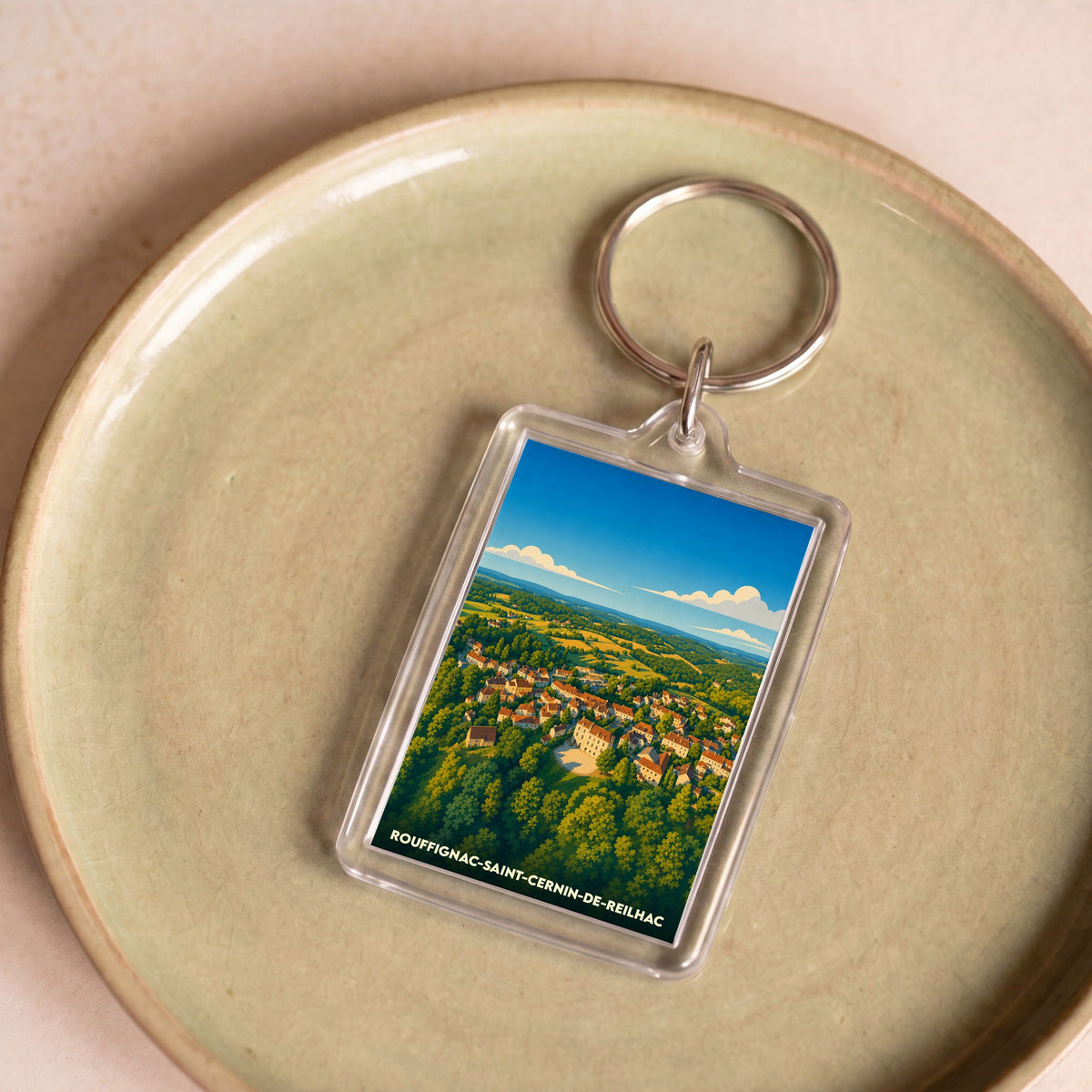 Porte-clés souvenir de la ville de Rouffignac-Saint-Cernin-de-Reilhac avec une illustration stylisée.