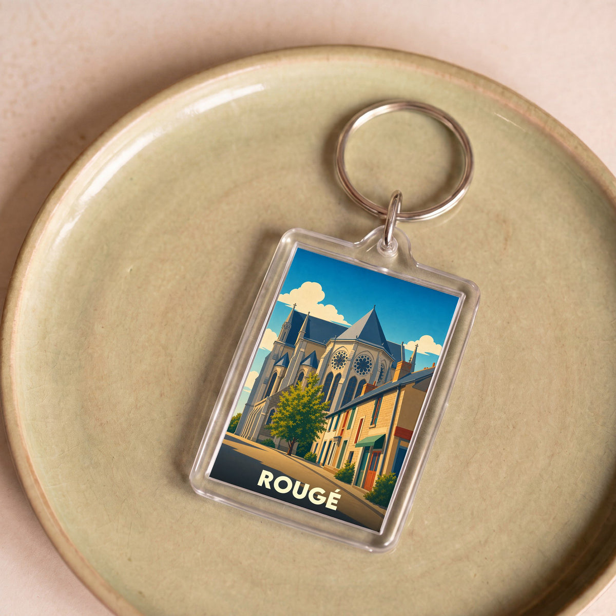 Porte-clés souvenir de la ville de Rougé avec une illustration stylisée.