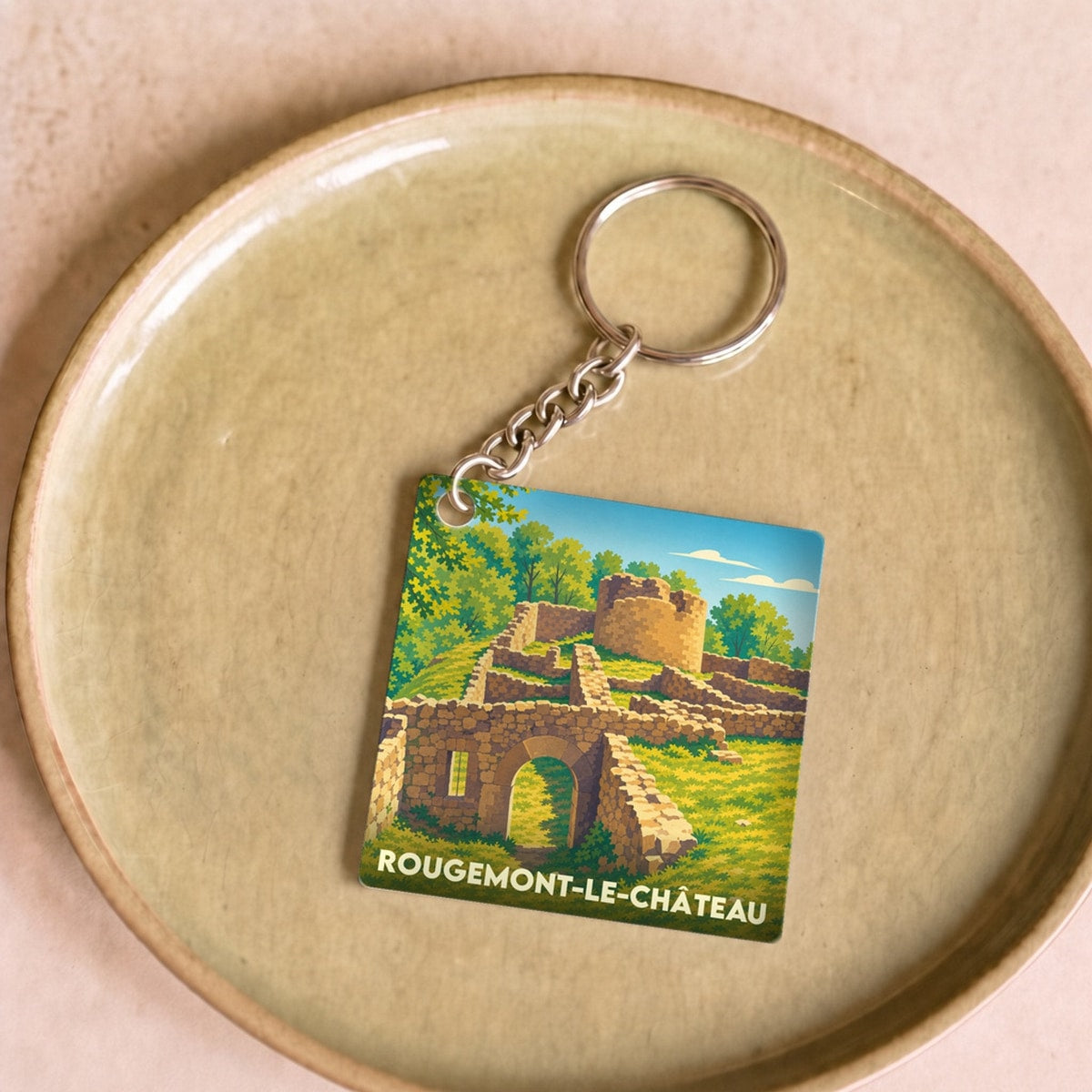 Porte-clés souvenir de Rougemont-le-Château avec une illustration stylisée des ruines de son château.