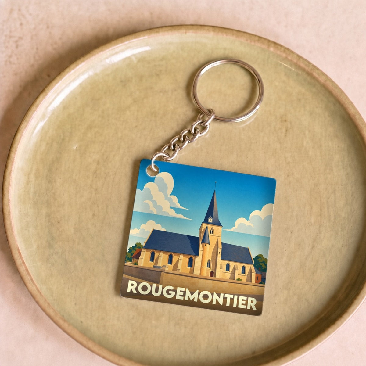 Porte-clés souvenir de la ville de Rougemontier avec une illustration stylisée de son église.