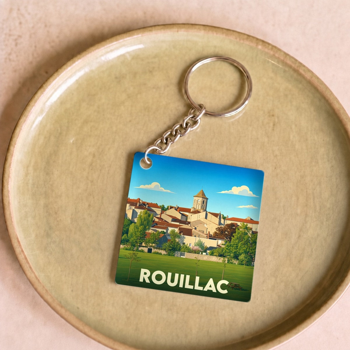 Porte-clés souvenir de la ville de Rouillac avec une illustration stylisée.