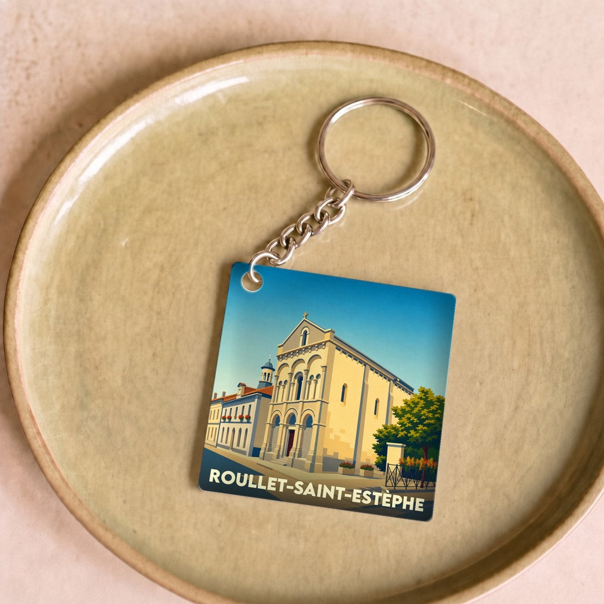 Porte-clés souvenir de la ville de Roullet-Saint-Estèphe avec une illustration stylisée de son église.