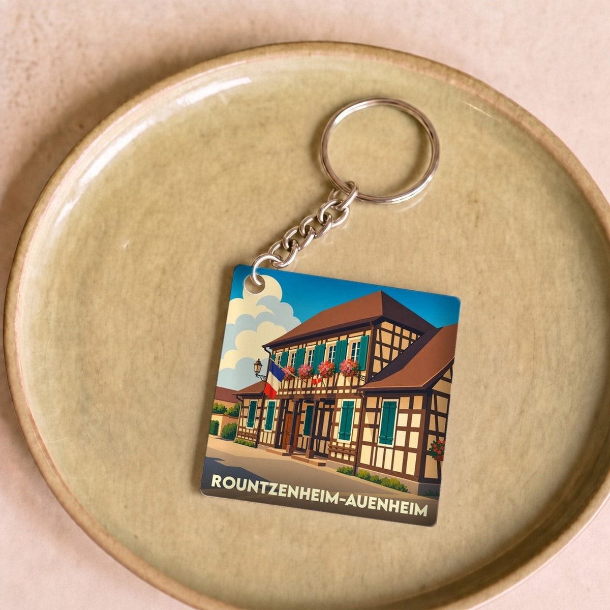 Porte-clés souvenir de la ville de Rountzenheim-Auenheim avec une illustration stylisée d'une maison à colombages.