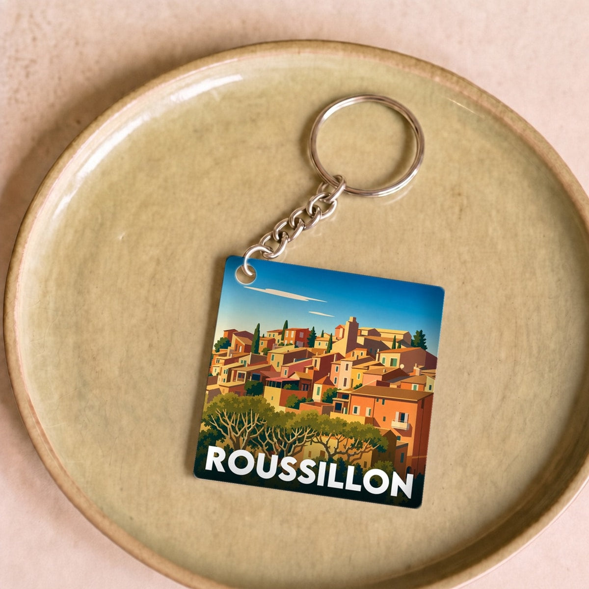 Porte-clés souvenir de la ville de Roussillon avec une illustration stylisée.