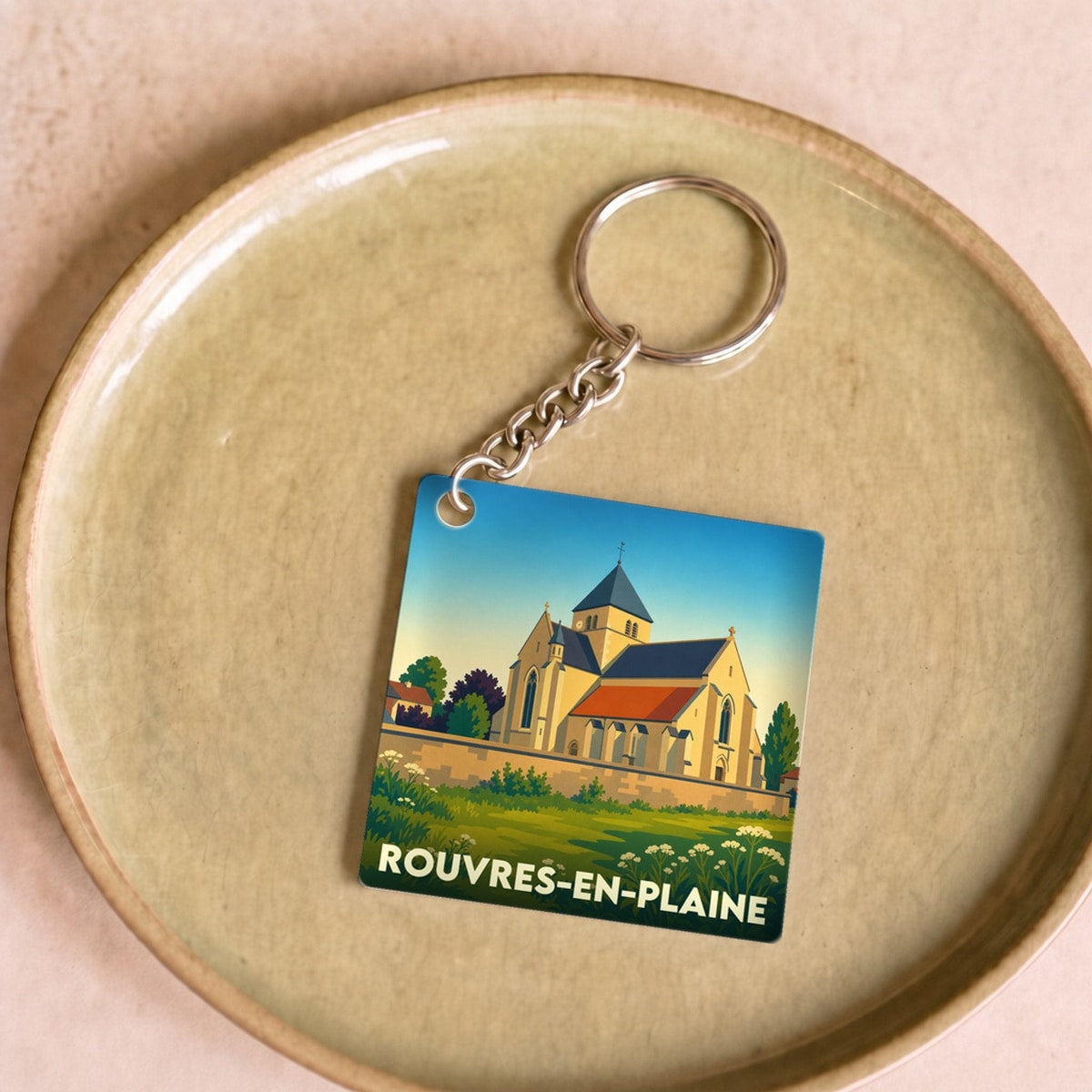 Porte-clés souvenir de la ville de Rouvres-en-Plaine avec une illustration stylisée de son église.