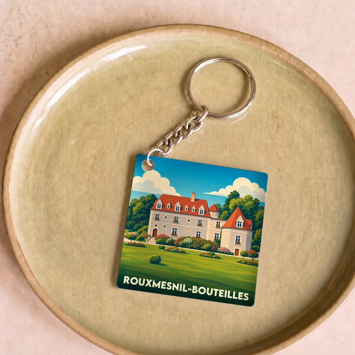 Porte-clés souvenir de la ville de Rouxmesnil-Bouteilles avec une illustration stylisée d'un château.