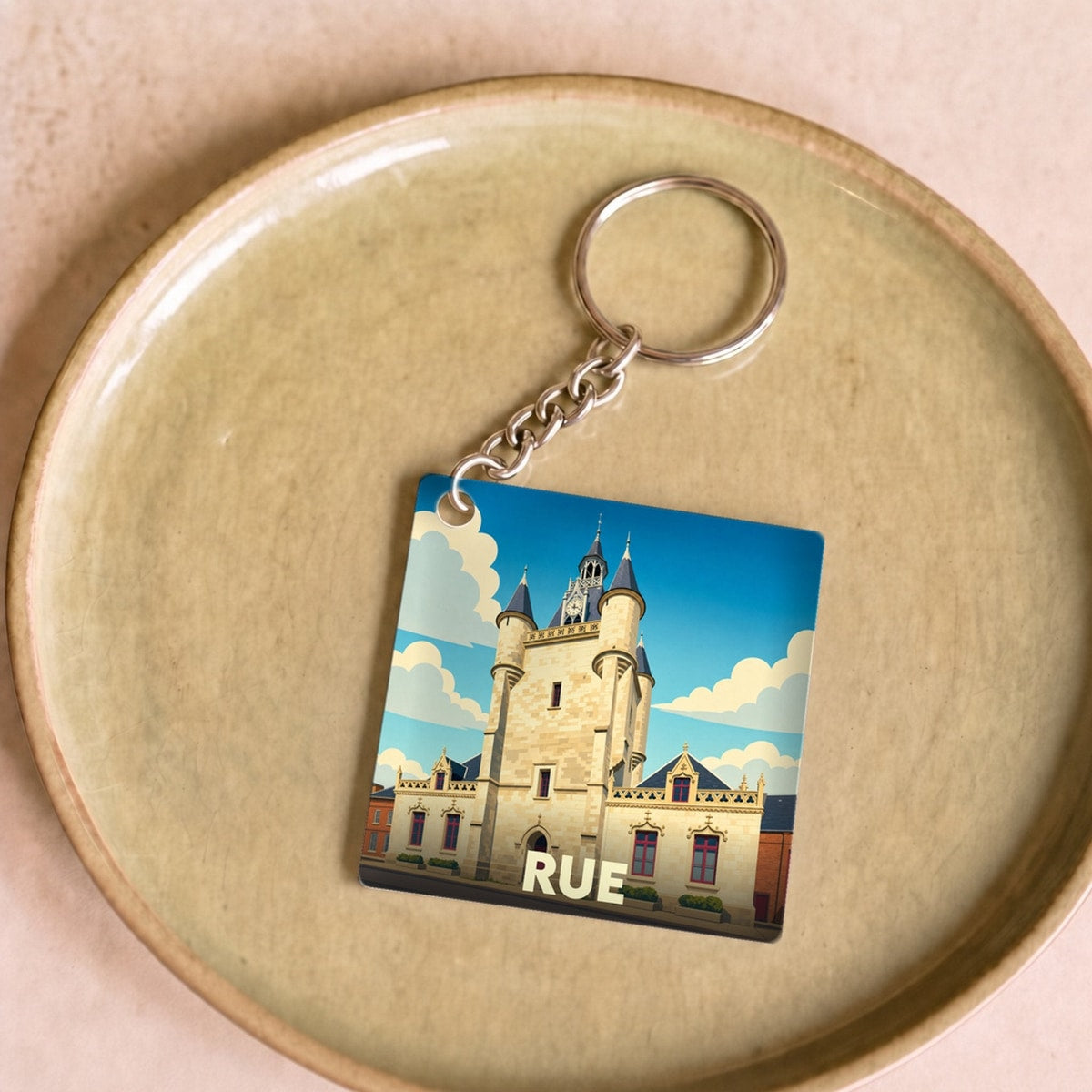 Porte-clés souvenir de la ville de Rue avec une illustration stylisée de son beffroi.