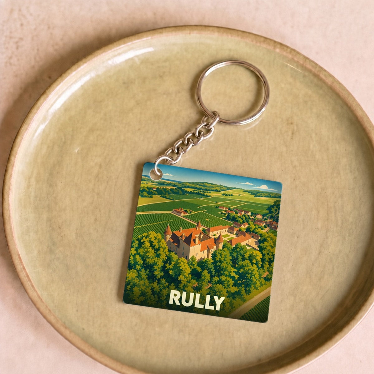 Porte-clés souvenir de la ville de Rully avec une illustration stylisée de son château et de ses vignobles.