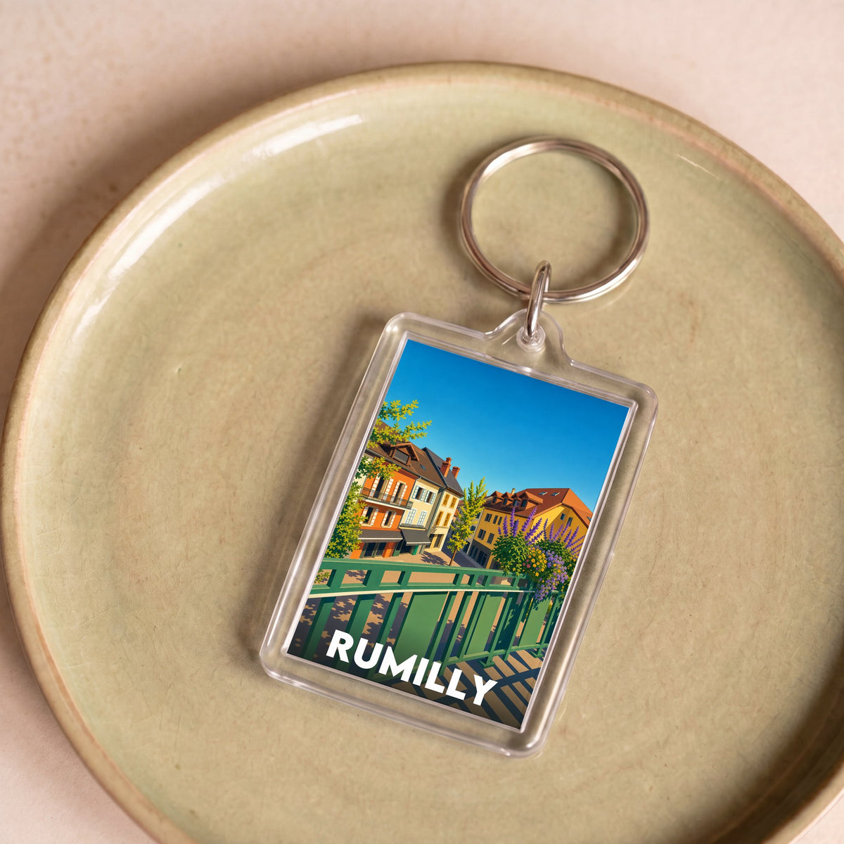 Porte-clés souvenir de la ville de Rumilly avec une illustration stylisée.