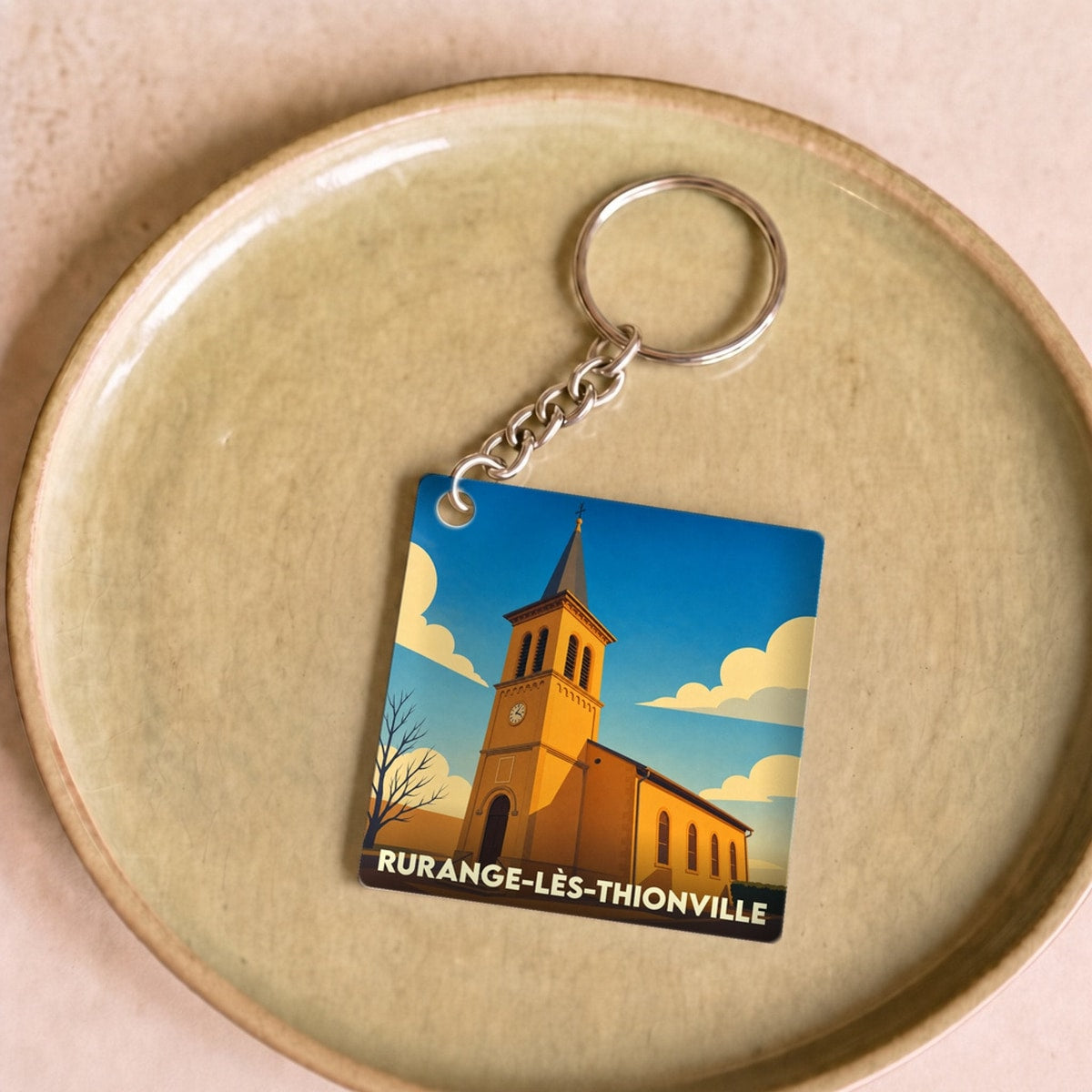 Porte-clés souvenir de la ville de Rurange-lès-Thionville avec une illustration stylisée de son église.