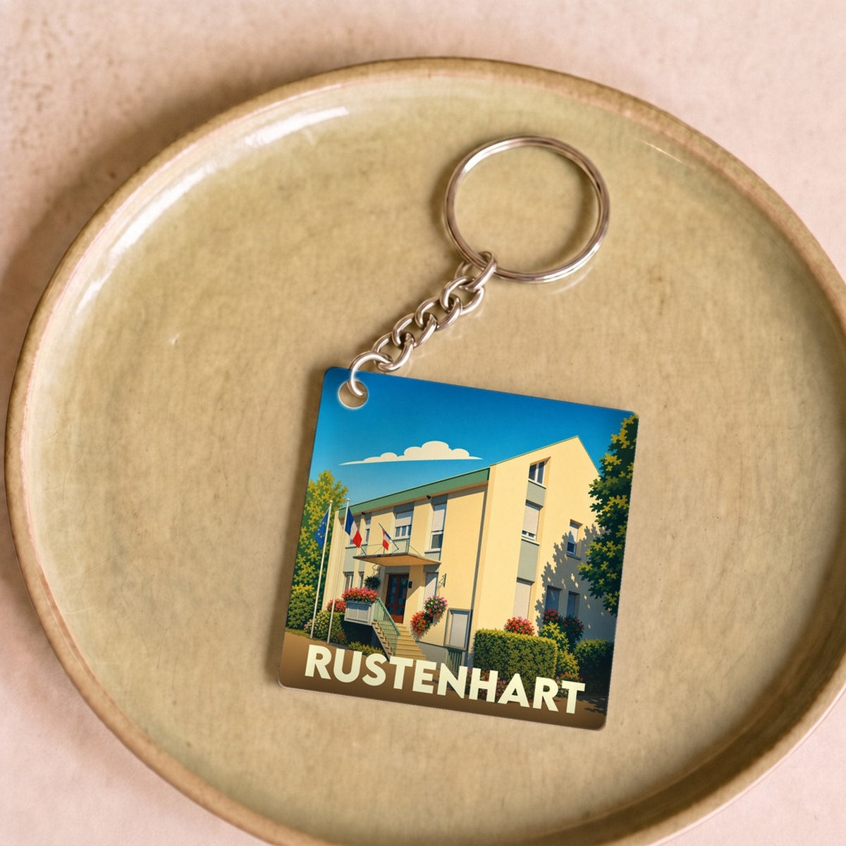 Porte-clés souvenir de la ville de Rustenhart avec une illustration stylisée de sa mairie.