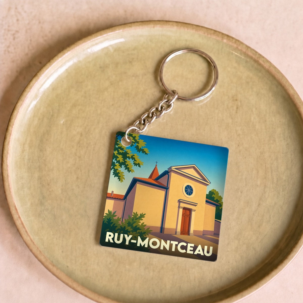 Porte-clés souvenir de la ville de Ruy-Montceau avec une illustration stylisée de son église.