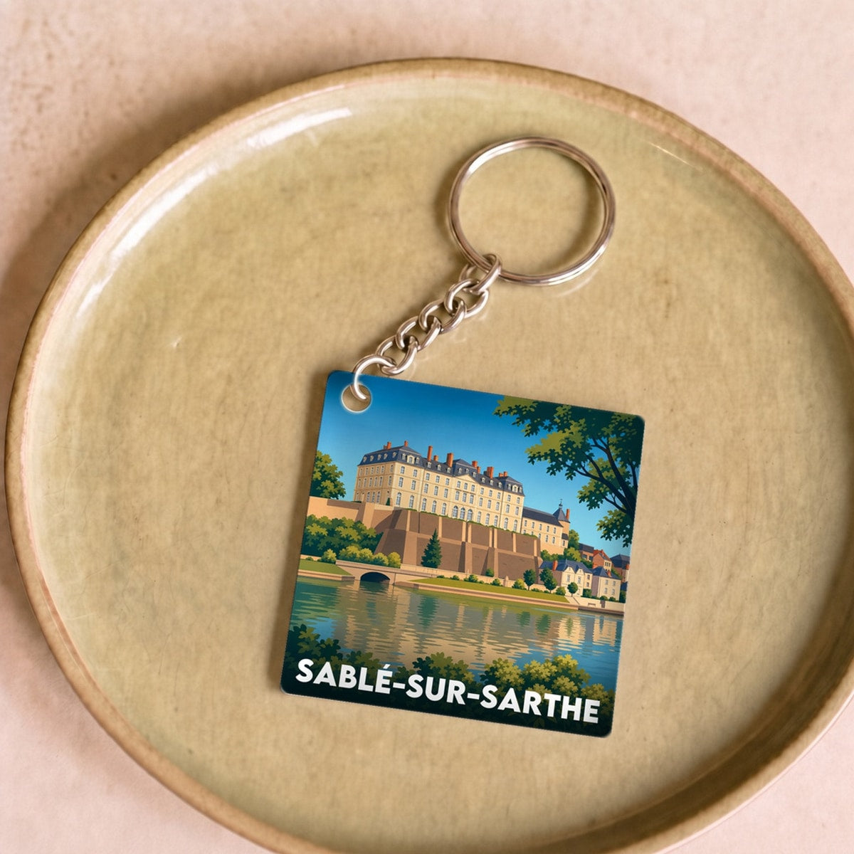 Porte-clés souvenir de la ville de Sablé-sur-Sarthe avec une illustration stylisée de son château.