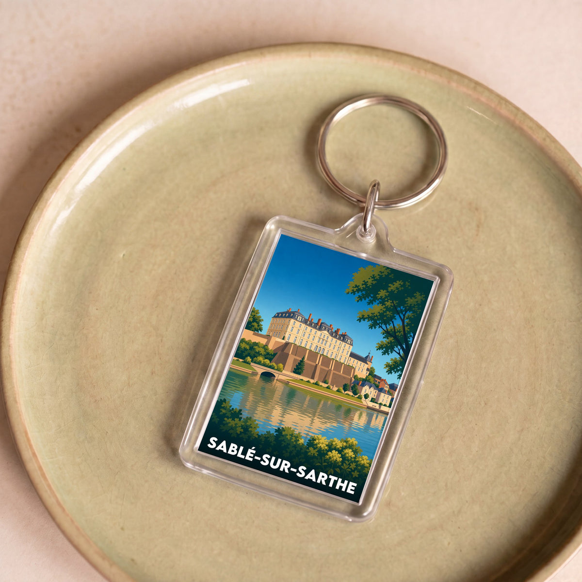 Porte-clés souvenir de la ville de Sablé-sur-Sarthe avec une illustration stylisée de son château.