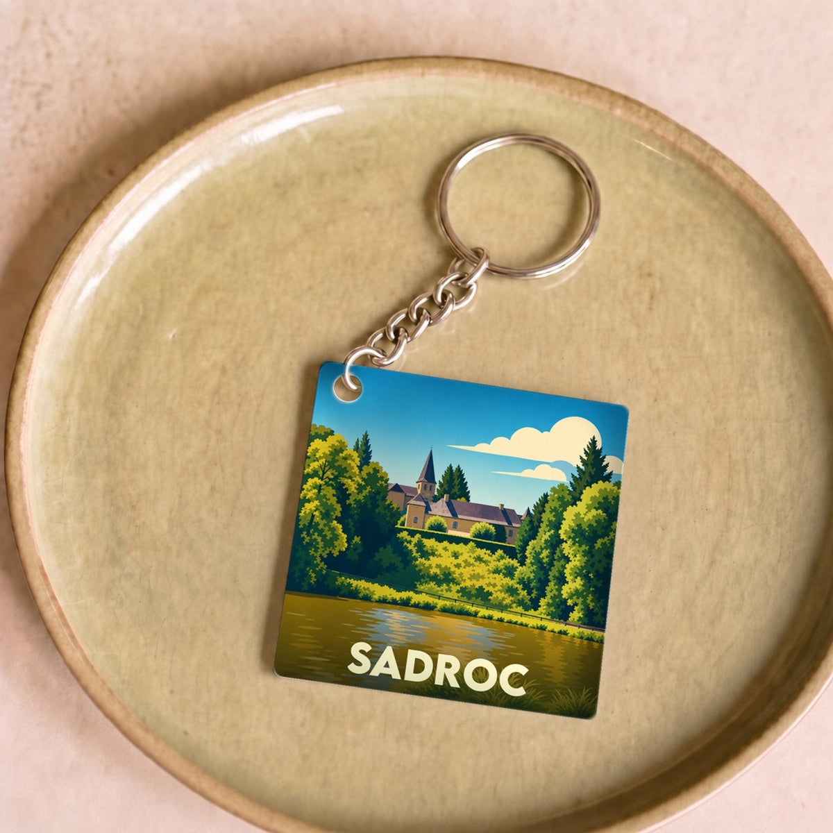 Porte-clés souvenir de la ville de Sadroc avec une illustration stylisée.