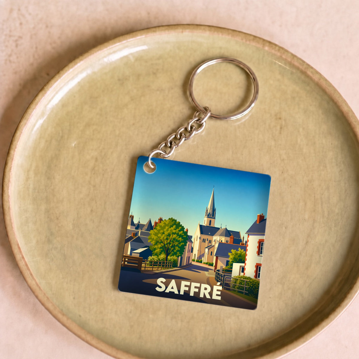 Porte-clés souvenir de la ville de Saffré avec une illustration stylisée.