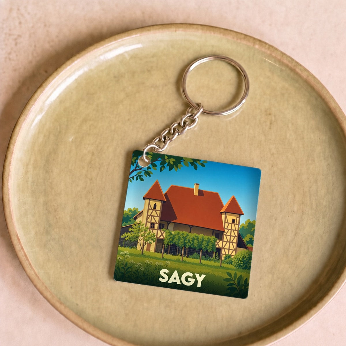 Porte-clés souvenir de la ville de Sagy avec une illustration stylisée.