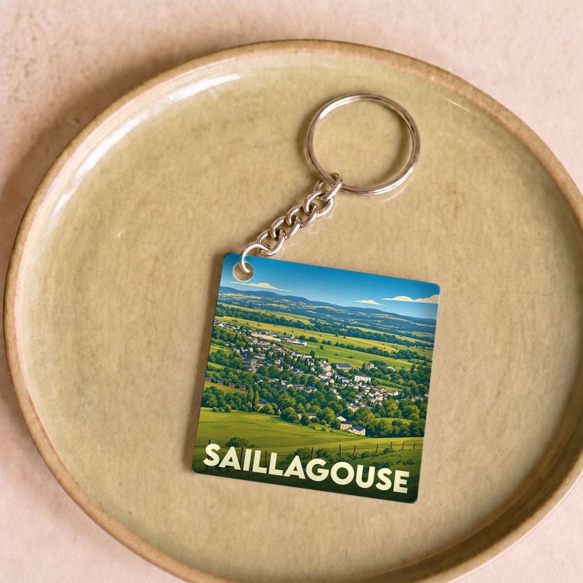 Porte-clés souvenir de la ville de Saillagouse avec une illustration stylisée de son paysage.