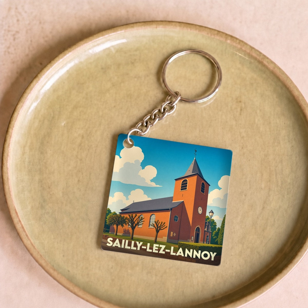 Porte-clés souvenir de la ville de Sailly-lez-Lannoy avec une illustration stylisée de son église.