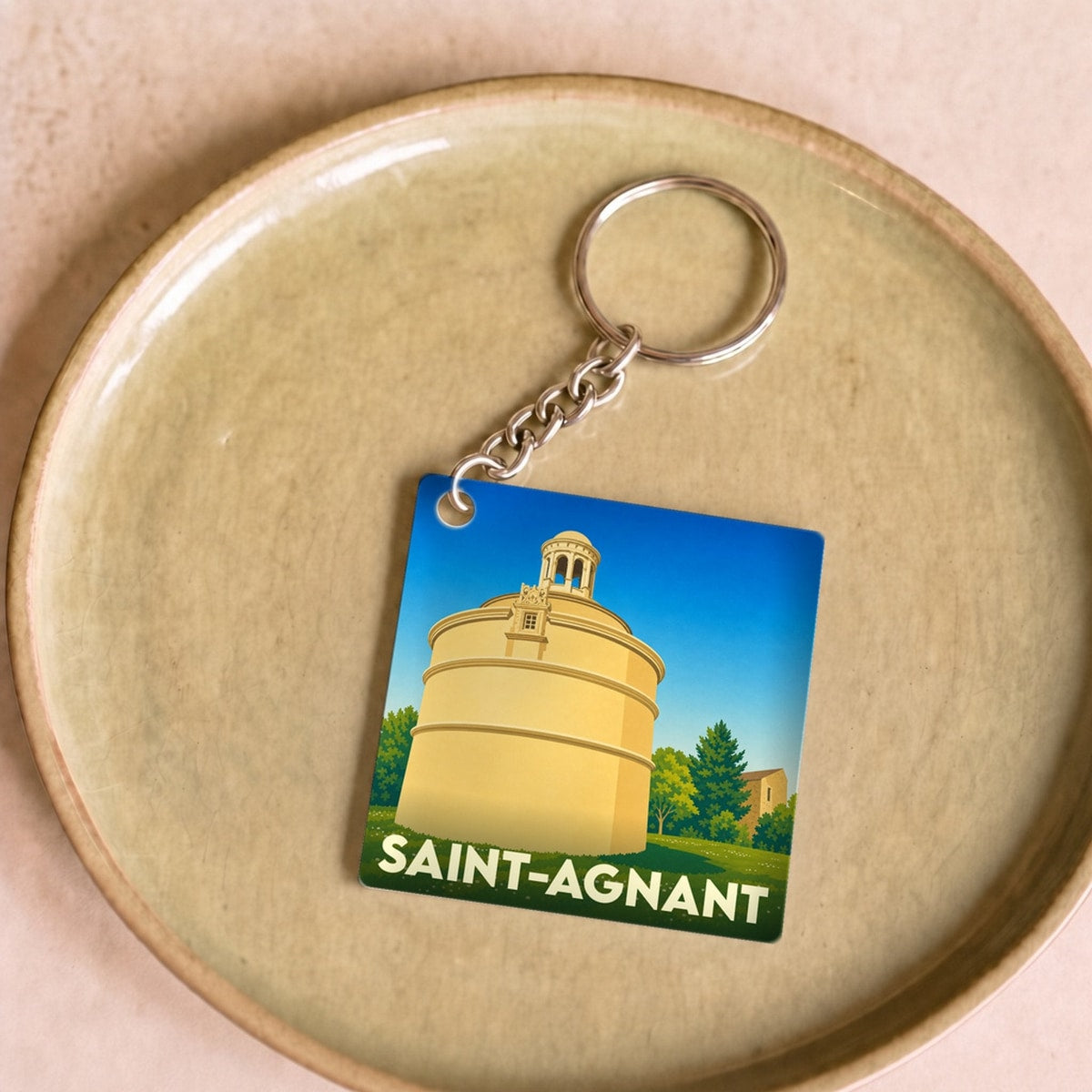 Porte-clés souvenir de la ville de Saint-Agnant avec une illustration stylisée.
