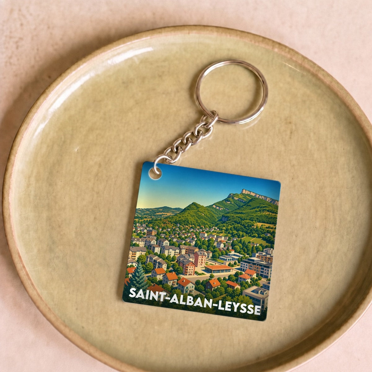 Porte-clés souvenir de la ville de Saint-Alban-Leysse avec une illustration stylisée d'un paysage montagneux.
