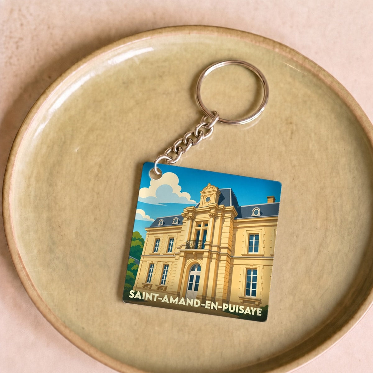 Porte-clés souvenir de la ville de Saint-Amand-en-Puisaye avec une illustration stylisée du château local.