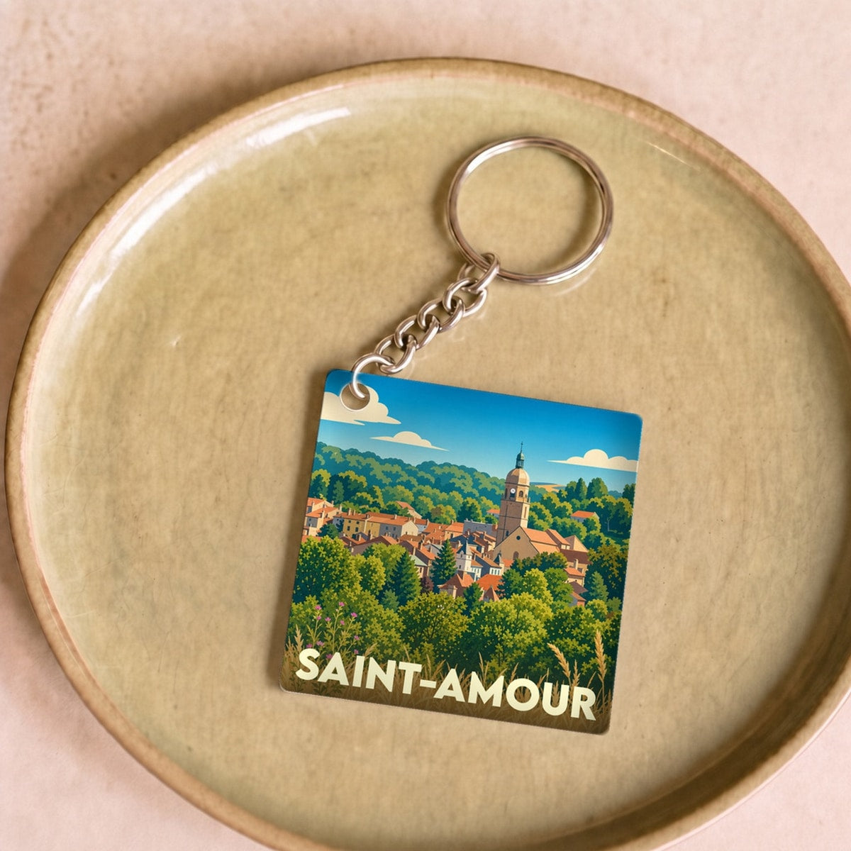 Porte-clés souvenir de la ville de Saint-Amour avec une illustration stylisée.