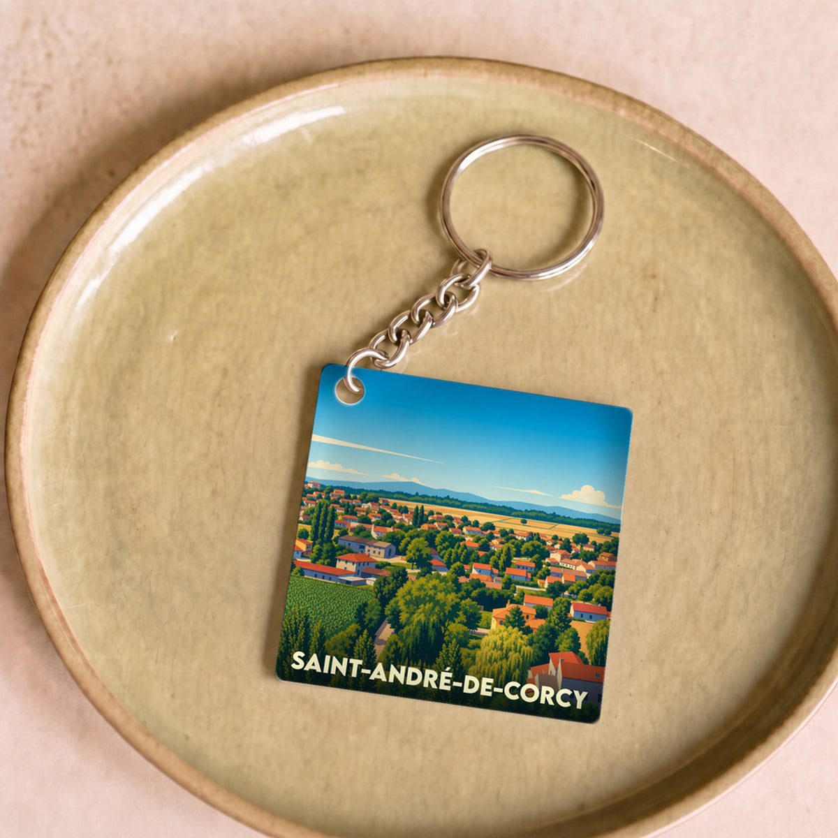 Porte-clés souvenir de la ville de Saint-André-de-Corcy avec une illustration paysagère stylisée.