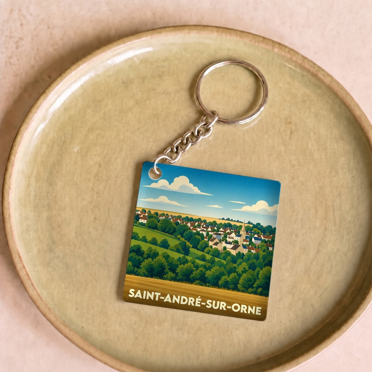 Porte-clés souvenir de la ville de Saint-André-sur-Orne avec une illustration stylisée.