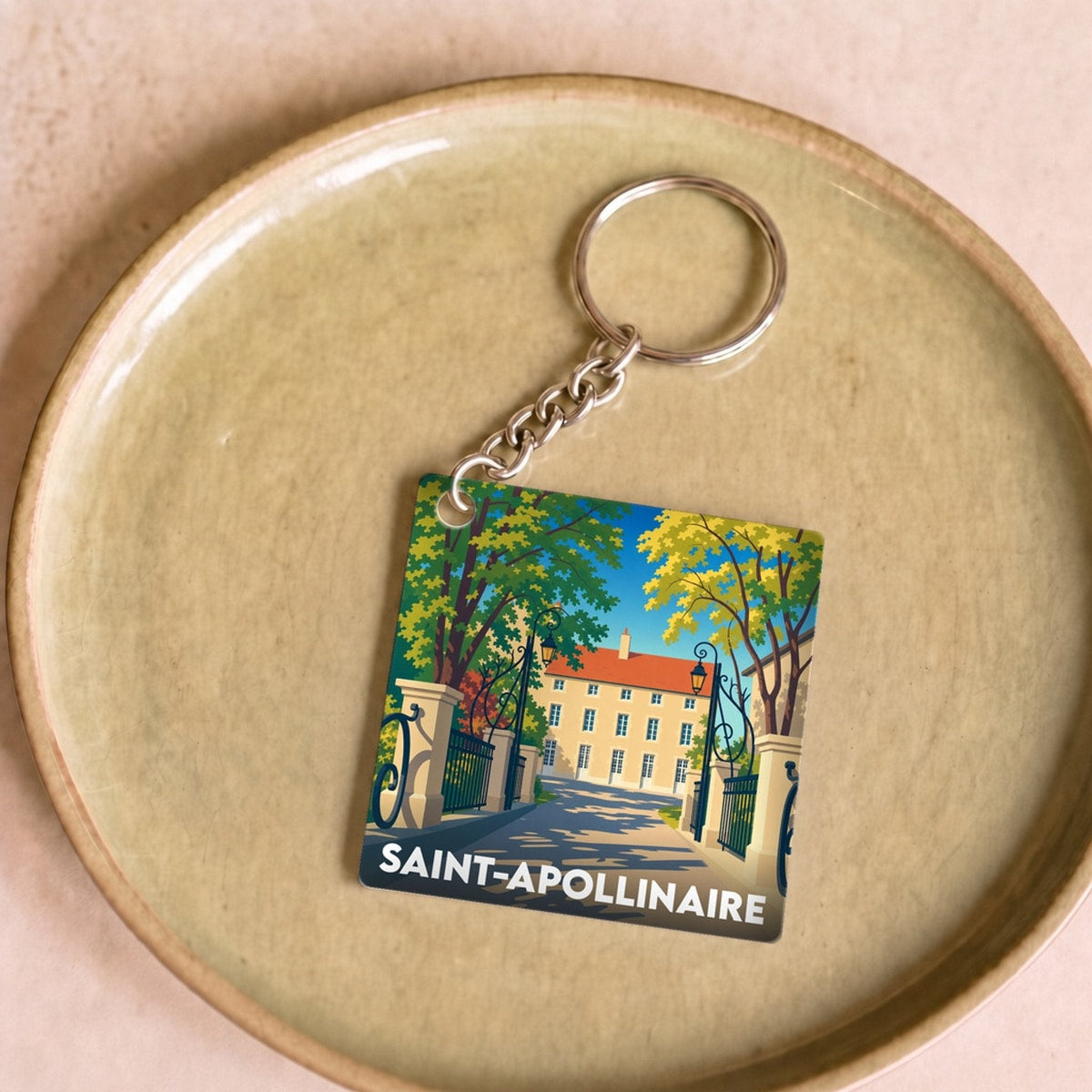 Porte-clés souvenir de la ville de Saint-Apollinaire avec une illustration stylisée d'un bâtiment historique.