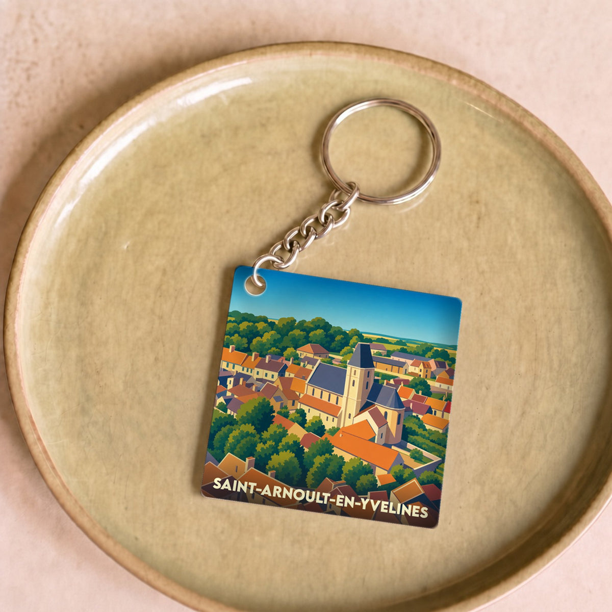 Porte-clés souvenir de la ville de Saint-Arnoult-en-Yvelines avec une illustration stylisée.