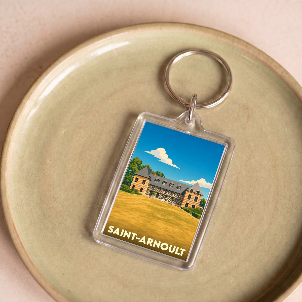 Porte-clés souvenir de la ville de Saint-Arnoult avec une illustration stylisée de son patrimoine.