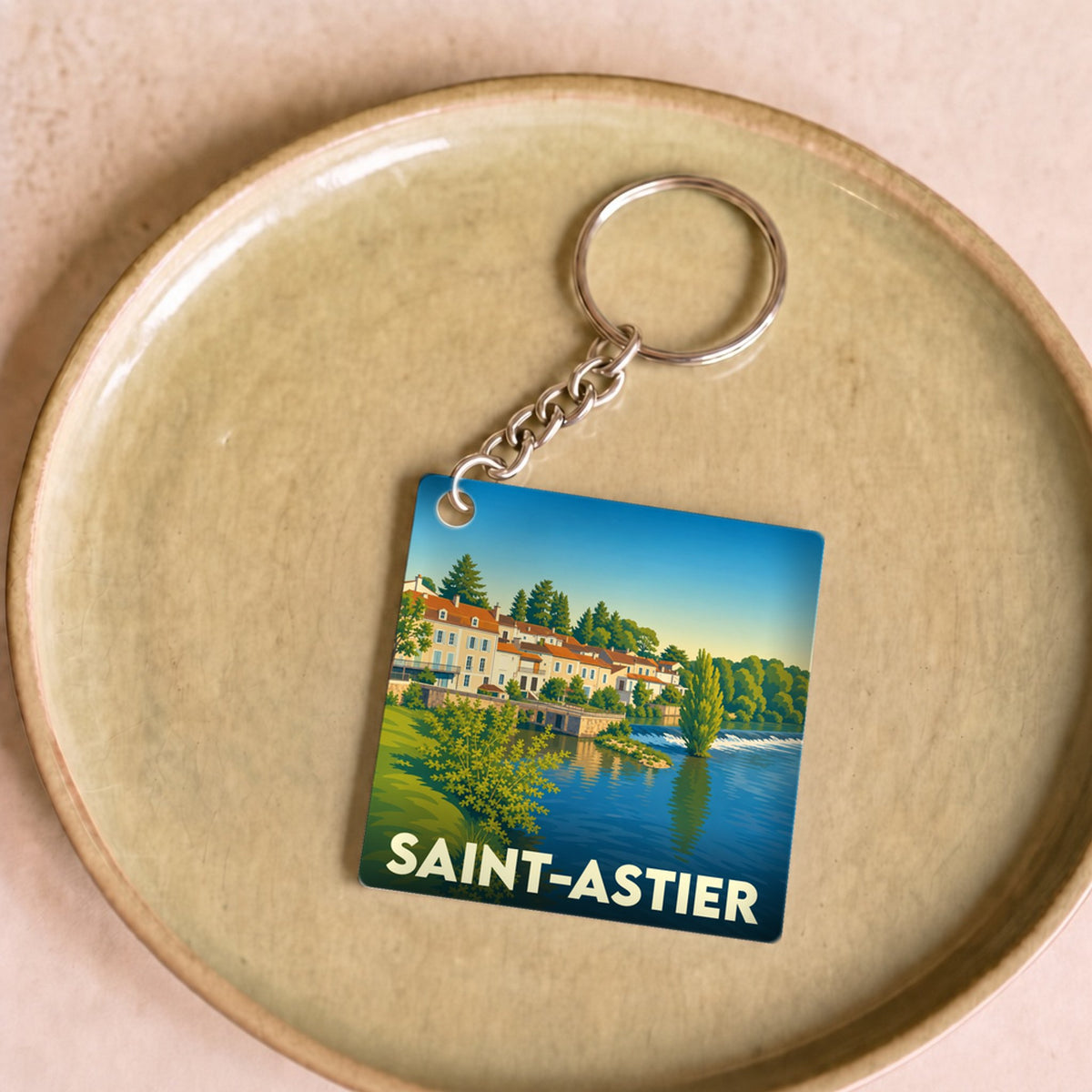 Porte-clés souvenir de la ville de Saint-Astier avec une illustration stylisée.