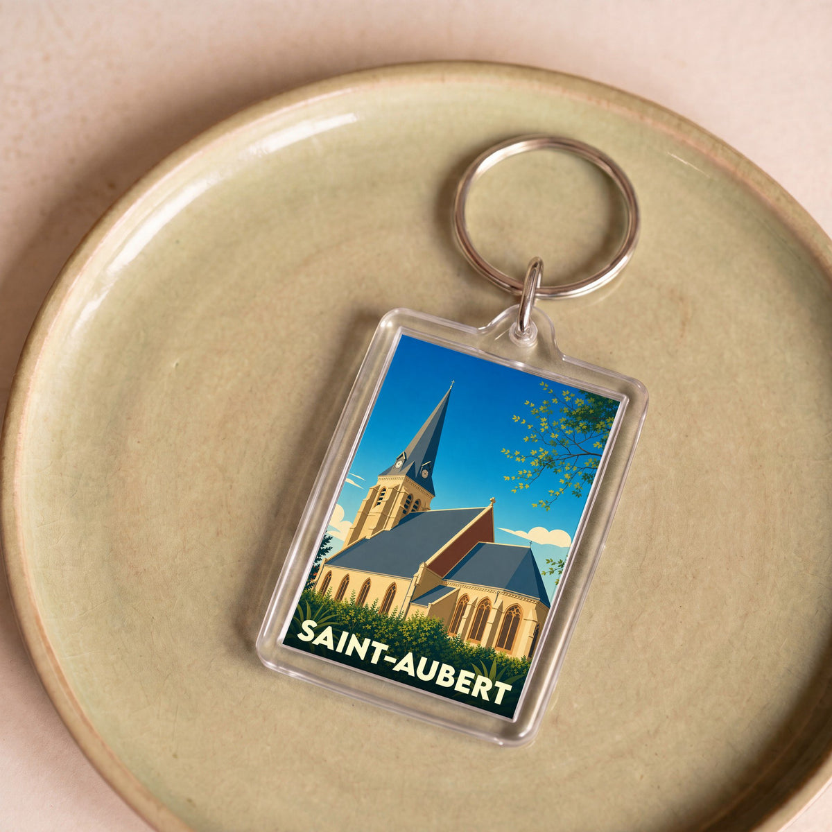 Porte-clés souvenir de la ville de Saint-Aubert avec une illustration stylisée de son église.